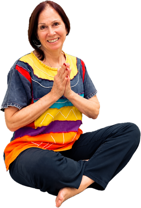 JWolfe, the artist, seated cross-legged with her hands together, smiling